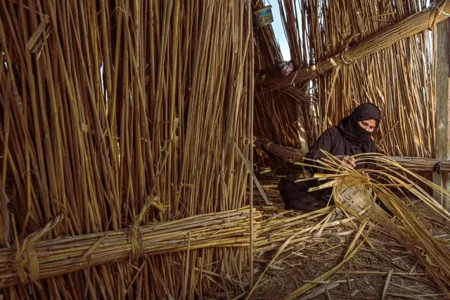 A woman works on manufacturing reeds