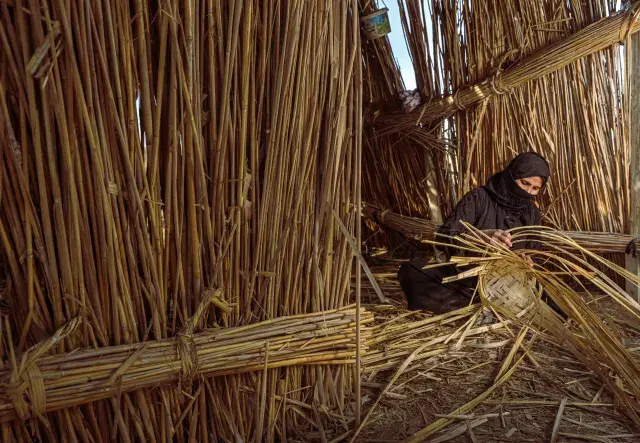 A woman works on manufacturing reeds